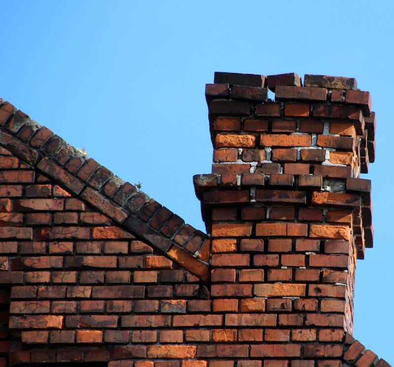 Damaged chimney on an Sterling home showing cracks and missing mortar